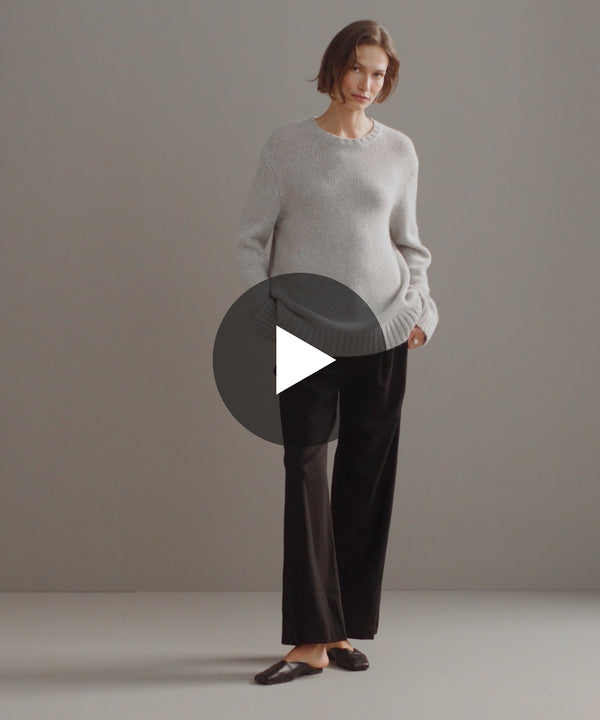 Model walking in studio in oversized crewneck cashmere sweater.