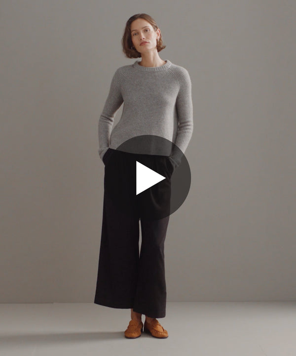 Model walking in-studio wearing Cashmere Fisherman Sweater in Grey.