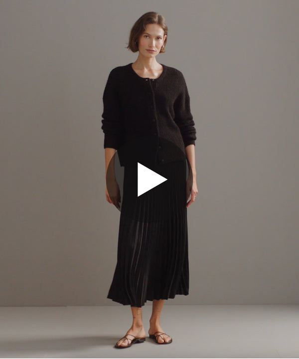 Model walking in-studio wearing Pleated Skirt in Black.